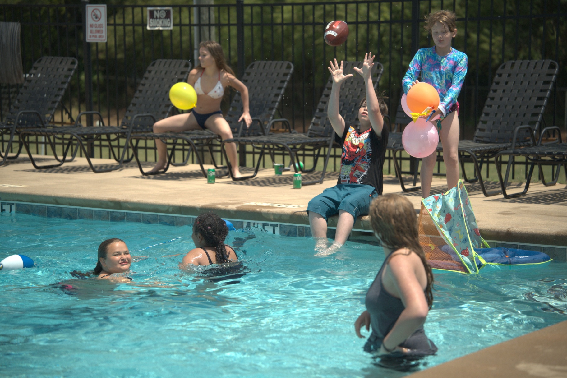 Kids playing football and balloons at the pool