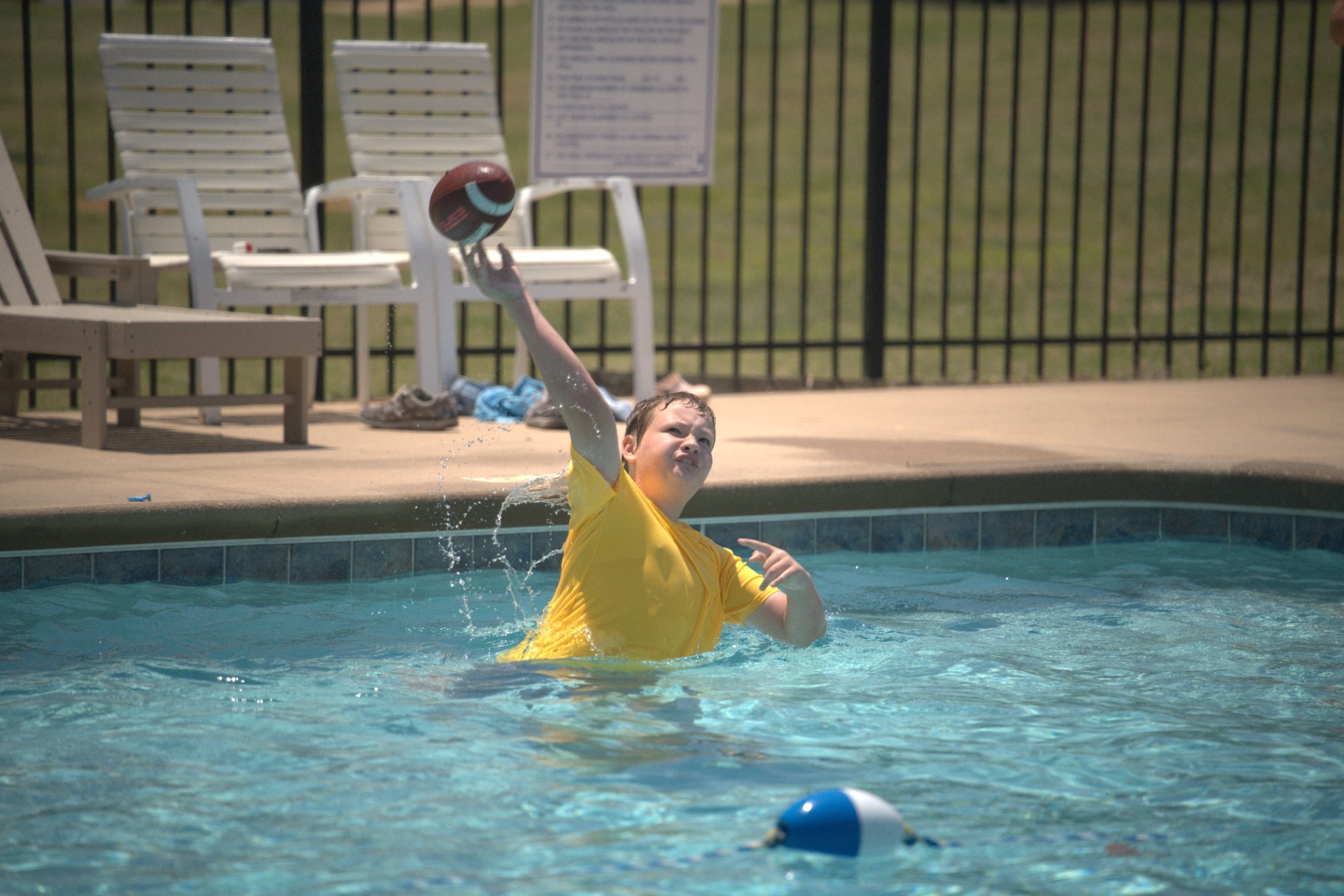 Boy catching a football in the pool